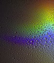 Water drops on glass with colorful rainbow background. Morning dew on the window with a refractive reflection Royalty Free Stock Photo
