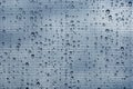 Water drops on glass window with mosquito net against gray sky Royalty Free Stock Photo