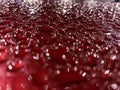 Water drops on a red glossy surface. Glare of light in water droplets. The surface of the car after finishing. Abstract background