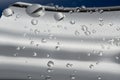 Water drops on a silver metallic surface with blue background