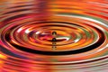 Water drops splash. Red and yellow colored ripples, reflections Royalty Free Stock Photo