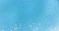 Water drops on the window, blue sky and clouds in the blurry background Royalty Free Stock Photo