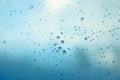 Water drops on the window, blue sky and clouds in the blurry background Royalty Free Stock Photo