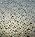 Water drops on window net mesh with glow of sun in morning sky at background Royalty Free Stock Photo