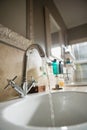 Water falling from faucet in bathroom sink Royalty Free Stock Photo