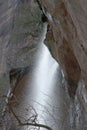 Water Falling Over Red Sandstone Cliffs with Branches in Winter Royalty Free Stock Photo