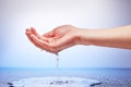 Water falling from womans hand on white and blue Royalty Free Stock Photo