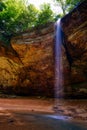 Water falls over the edge of Ash Cave located in Hocking Hills State Park in Ohio Royalty Free Stock Photo