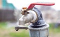 Water faucet on the background of nature. Opening or closing a faucet to save water indicates a water shortage problem. Rustic Royalty Free Stock Photo