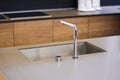 Water faucet in the modern kitchen. Concrete countertop and wooden kitchen