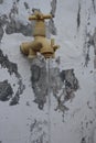 Water faucet planted on the wall with a stream of flowing water Royalty Free Stock Photo