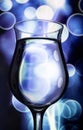 Water-Filled Hurricane Glass with Blue Bokeh Background