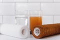 Water filter cartridge used and a glass of dirty water and new pure filter with a glass of clean water from domestic osmosis Royalty Free Stock Photo