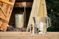Water filter jug and a transparent glass cup of clean water in front of wooden draw well outdoors in summer evening