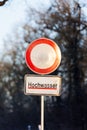 Water flood sign Hochwasser - Flood at Germany forest city park. Road close drive prohibited due Weather seasonal