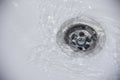 Water flow into drain in white bath Royalty Free Stock Photo