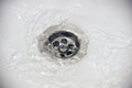 Water flow into drain in white bath Royalty Free Stock Photo