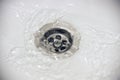 Water flow into drain in white bath Royalty Free Stock Photo
