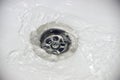 Water flow into drain in white bath Royalty Free Stock Photo