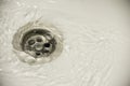 Water flow into drain in white bath Royalty Free Stock Photo