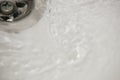 Water flow into drain in white bath Royalty Free Stock Photo