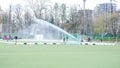 Water flow from a hose waters the field hockey stadium