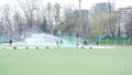 Water flow from a hose waters the field hockey stadium