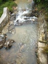 the water flow that looks a bit cloudy because of tin mining waste and full of garbage