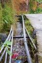 Water flow in polluted drainage stream in village Royalty Free Stock Photo