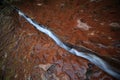 Water flowing through fissure in red rock, Zion National Park, Utah