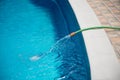 Water flowing from the hose into the pool, filling, servicing Royalty Free Stock Photo