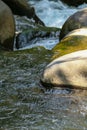 Water flowing over rocks in a mountain stream, closeup of photo Royalty Free Stock Photo