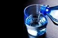 Water flowing from plastic bottle into a glass Royalty Free Stock Photo