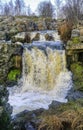 Water flowing rapidly in small river and waterfall