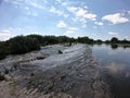 Water flows through the dam of Mygiivska HPP. Rapids and river dam on the Southern Bug. Group of people resting on the river water Royalty Free Stock Photo