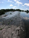 Water flows through the dam of Mygiivska HPP. Rapids and river dam on the Southern Bug. Group of people resting on the river water Royalty Free Stock Photo