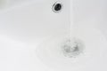 Water flows from the faucet into the sink. The concept of sewer and drain blockage, plumbing repair and prevention