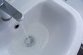 Water flows from the faucet into the sink. The concept of sewer and drain blockage, plumbing repair and prevention