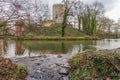 Water flows out of the moat into a stream between stones, tower of the Stein Castle ruins on a hill