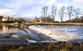Water flows over a man-made weir in England