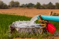 Water flows from pipes into a basin in rice fields near arid soil Royalty Free Stock Photo