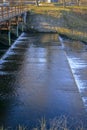 Water that flows silently through the flat steps of the dam near the shore