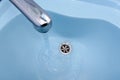 Water flows from the tap in a blue washbasin Royalty Free Stock Photo