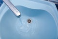 Water flows from the tap in a blue washbasin Royalty Free Stock Photo