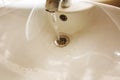 Water flows from the tap. Dirty washbasin and drain hole Royalty Free Stock Photo