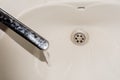 Water flows from the tap into the sink. Dirty plumbing fixtures and dishes Royalty Free Stock Photo