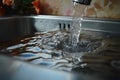 Water and food particles collect in the stainless steel sink drain