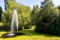 Water fountain surrounded by green algae in lake at Sefton Park Liverpool August 2019