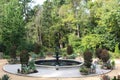 A water fountain surrounded by potted plants and lined by a forest in North Carolina Royalty Free Stock Photo