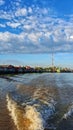 Water froth from the ship& x27;s engine splits a small river, you can see native houses above the water